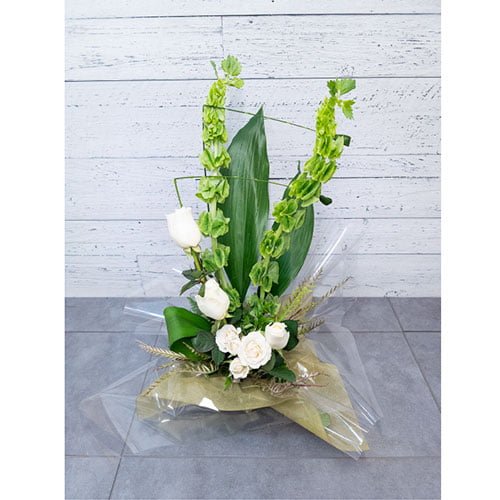 Arrangement de roses blanches et de cloches d’Irlande