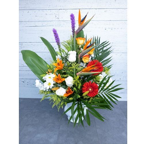 Arrangement composé de fleurs rouges, oranges et blanches