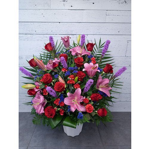Arrangement composé de fleurs rouges, roses et mauves