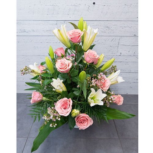 Arrangement composé de lys blanc et de roses roses