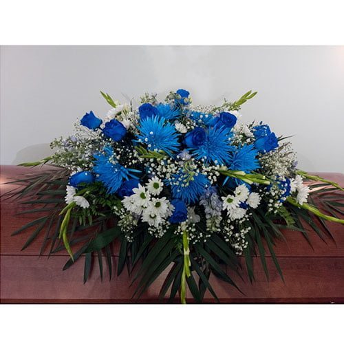 Coussin de cercueil composé de roses et de chrysanthèmes bleus