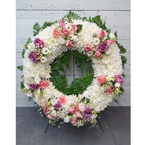 Couronne composée de fleurs blanches, mauves et roses