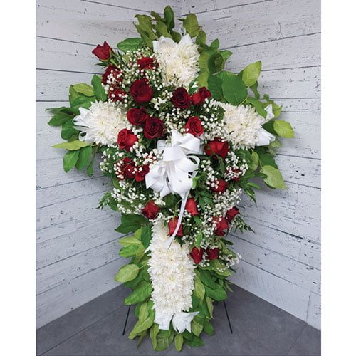 Croix composée de fleurs blanches et de roses rouges