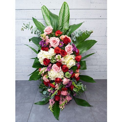 Arrangement composé de fleurs rouges, roses et blanches