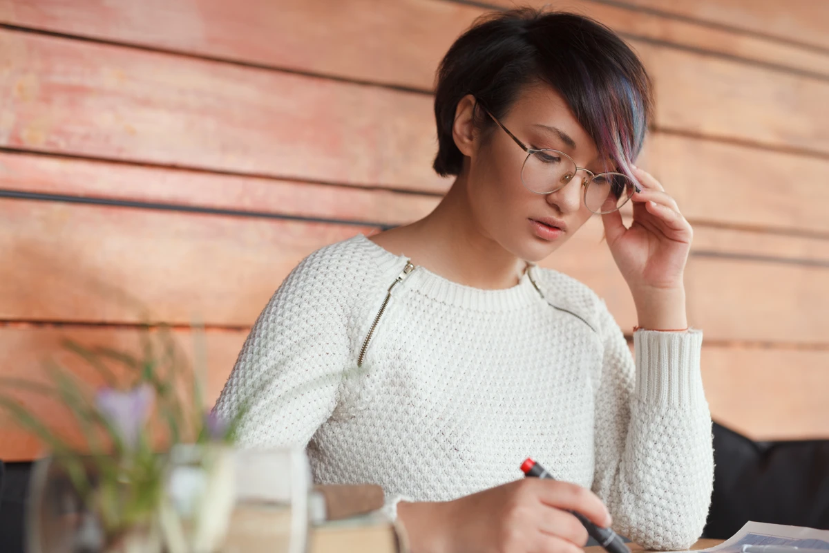 Femme écrivant les éléments essentiels d’un avis de décès.