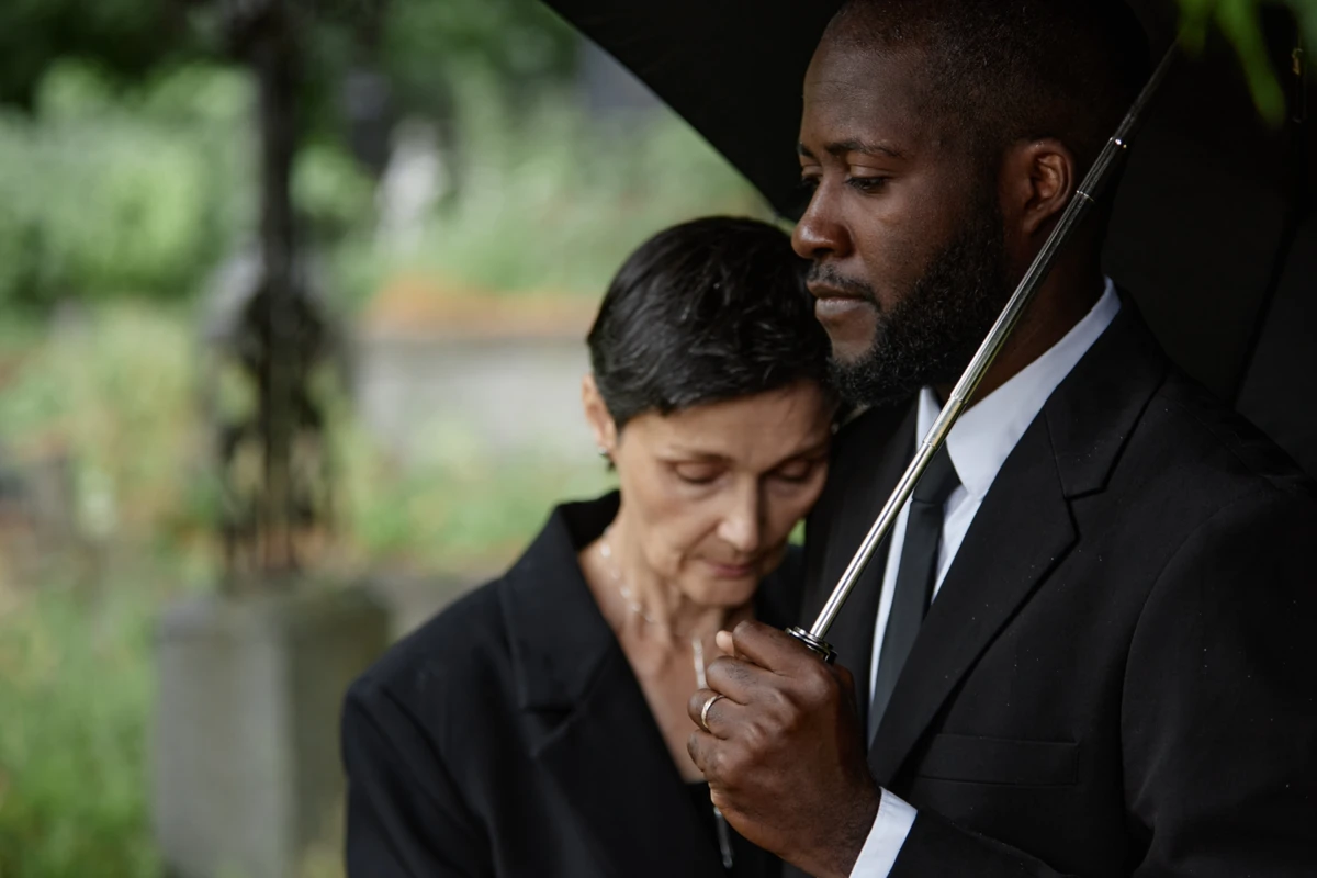 Man and woman experiencing mourning, in tribute to the deceased.